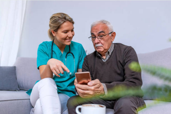 Nurse helping grandpa on phone